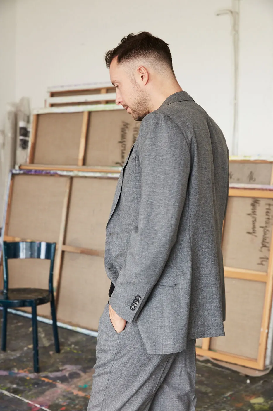 Simon Karim im Anzug in einem Künstleratelier, aus seiner Zeit als Art Director