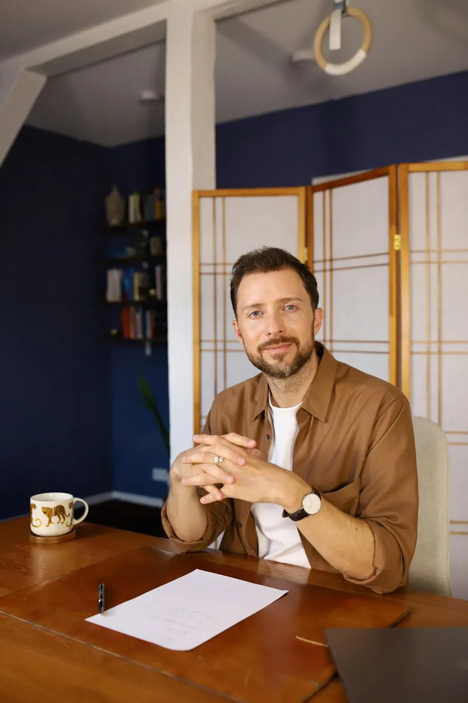 Simon Karim sitzt in seiner Praxis am Schreibtisch