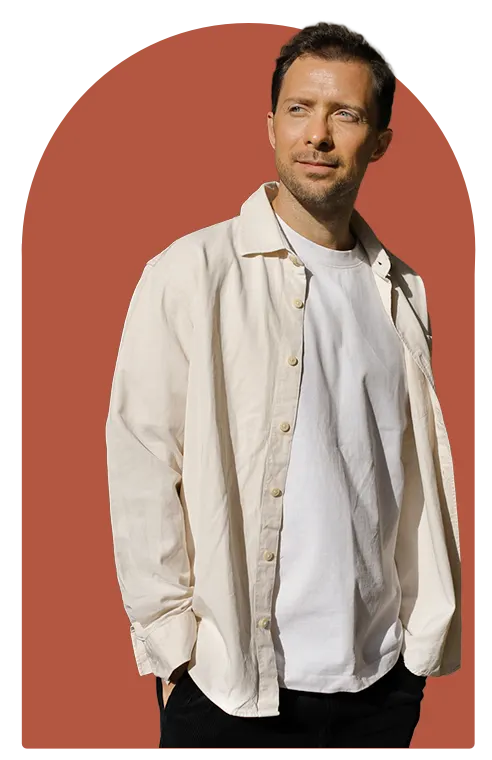 Simon Karim, traumasensibler Wut-Coach, im hellen Hemd vor einem terrakottafarbenen Bogen